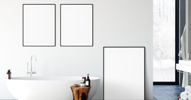 Blank painting frames on a bathroom white wall.