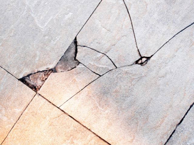 A close up photo of broken tile flooring.