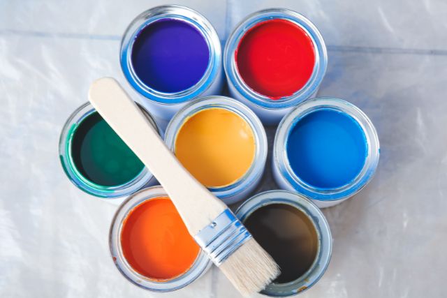 Different colors of opened cans of paints.