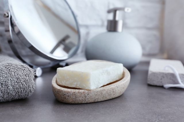 A soap dish made out of ceramic in a gray bathroom vanity.