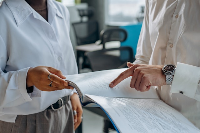 A man and a woman going through various document to understand different building codes.