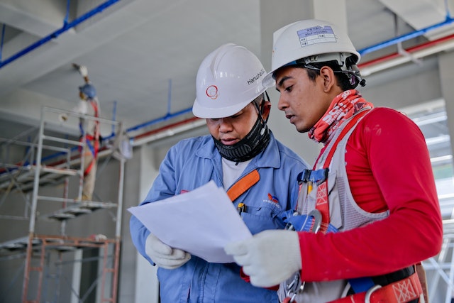 Two workers reviewing the construction permit.