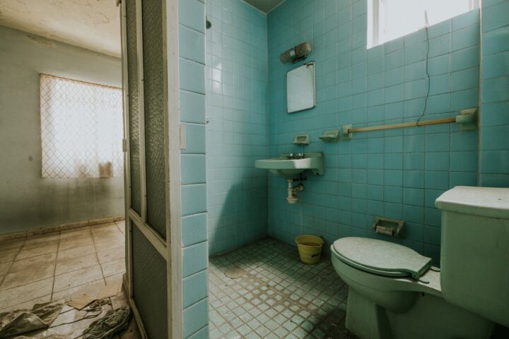 View of a Bathroom and Part of a Room in an Abandoned Dirty House.