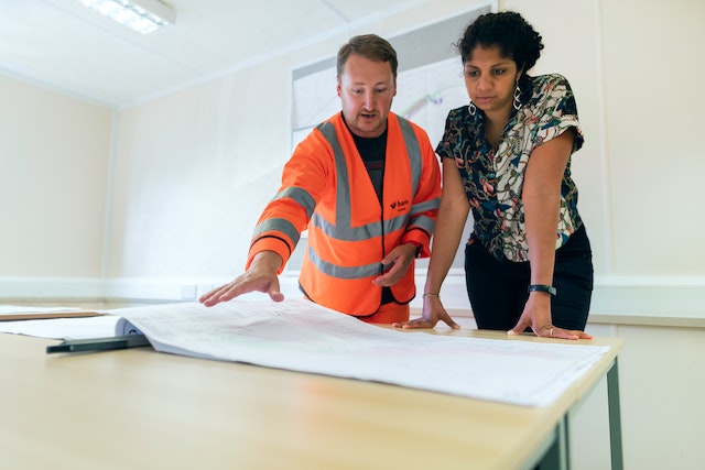 A man and a woman discussing the floor plan for a renovation.