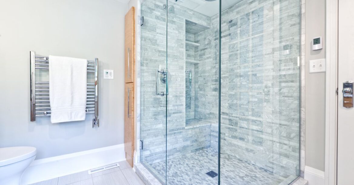 A clean glass shower partition and door in a bathroom.