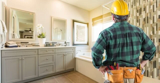 A licensed tradesman looking at a newly constructed bathroom.