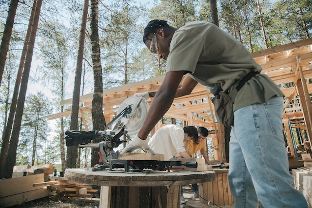 A man wearing PPE while using a circular saw and doing some renovation.