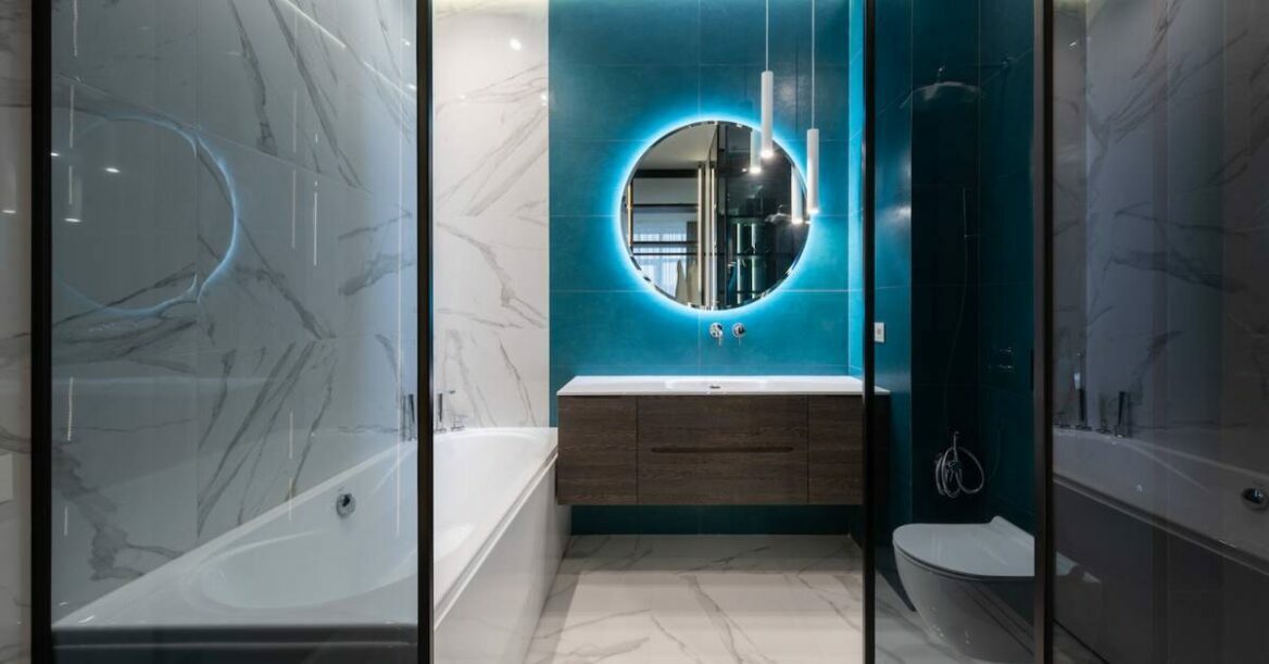 Contemporary interior of bathroom with bathtub and round mirror.