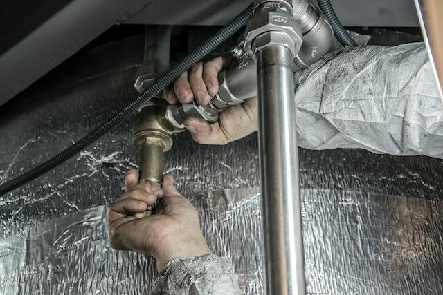 A plumber doing regular check up and maintenance on bathroom pipes.