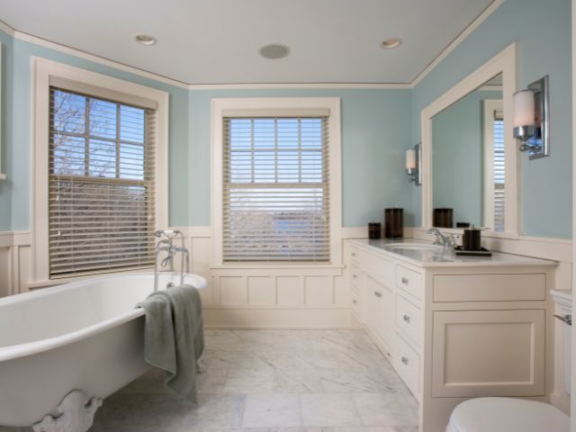A small bathroom white white and light blue green paint.