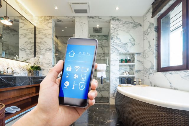 A smartphone controlling lights and fixtures in a bathroom.