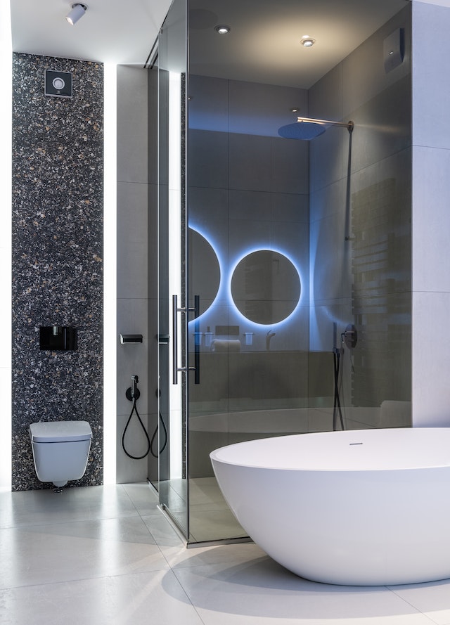 Interior of modern spacious bathroom with bright lamps and smart mirrors.