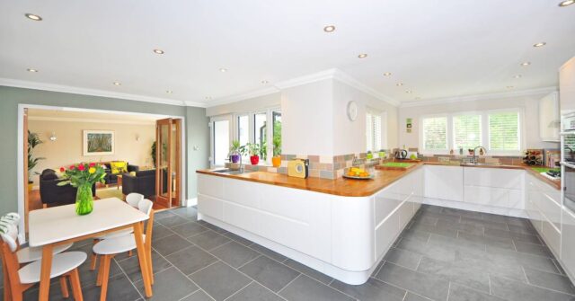 A spacious kitchen with white and brown countertop.