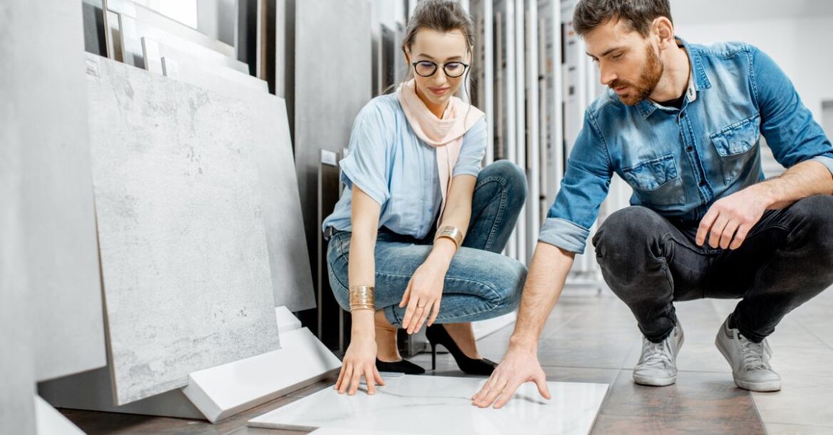 A couple checking out different tiles in a store.