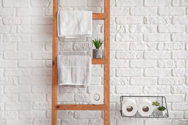 An upcycled ladder that. turned into bathroom towel holder.