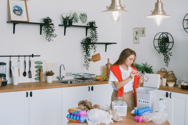 Young woman utilizing wastes in modern kitchen.