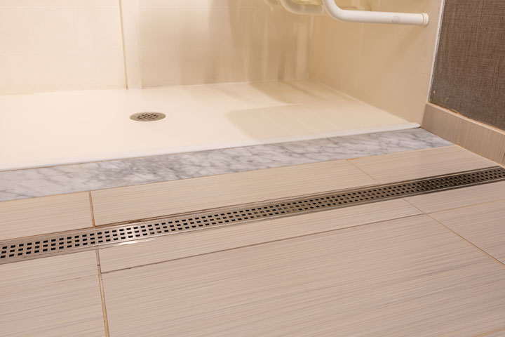 Close up view showing how flat the drain is to allow wheelchairs to roll over it with no issues.