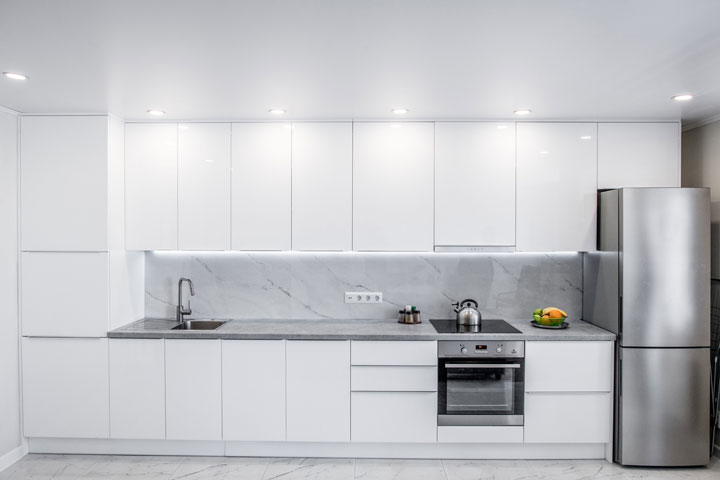 Sleek white and elegant kitchen with marble splashback and bench