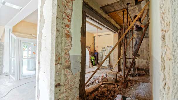 A demolished space with workers doing renovations.