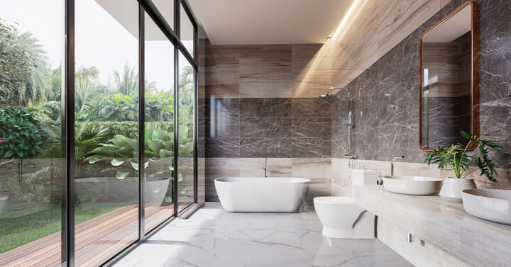 Luxurious bathroom with marble walls and floors, a freestanding tub, vessel sinks, and floor-to-ceiling windows overlooking lush greenery.