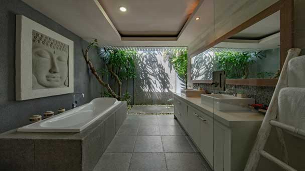 A unique bathroom design that has open roof and different plants.