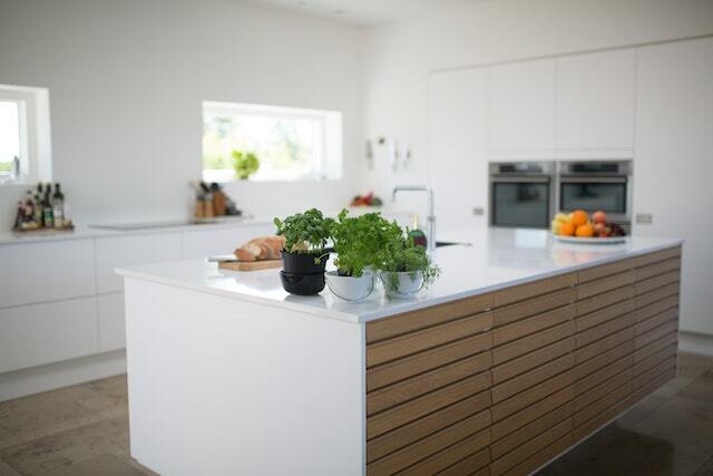 Beautiful white kitchen island with timber paneling one on side