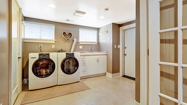 Large laundry in family home showing washer, dryer and sink.