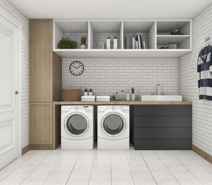 A dedicated laundry room with washing machine, dryer, sink and plenty of storage options.