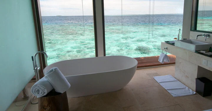 Free standing bathtub overlooking the water from a luxury bathroom