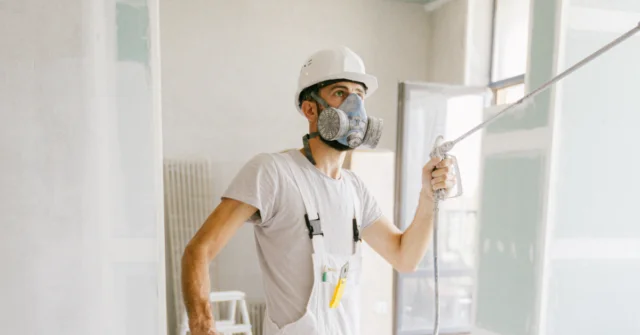 A man doing renovations while wearing proper personal protective equipment.