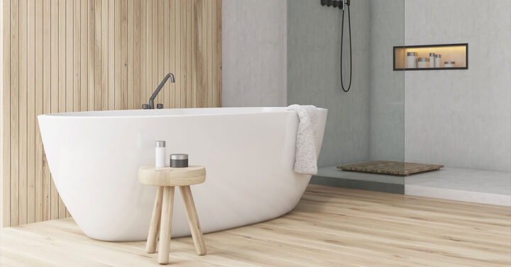 Minimalist bathroom with a white freestanding tub, wood accents, a small stool, and a walk-in shower with a built-in shelf.
