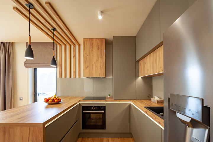 Modern designed kitchen with timber bench, flooring and highlights.