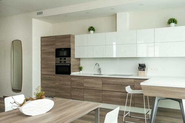 Wooden drawers and kitchen cupboard with white overhead shelving units