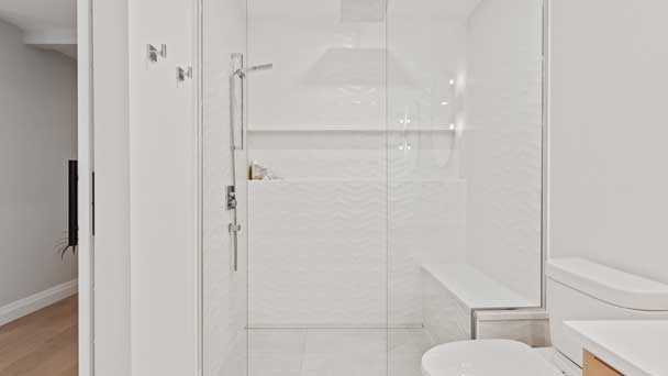 White and clean looking bathroom with frameless shower door.