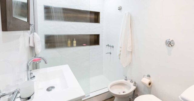 A small bathroom design with glass shower partition.