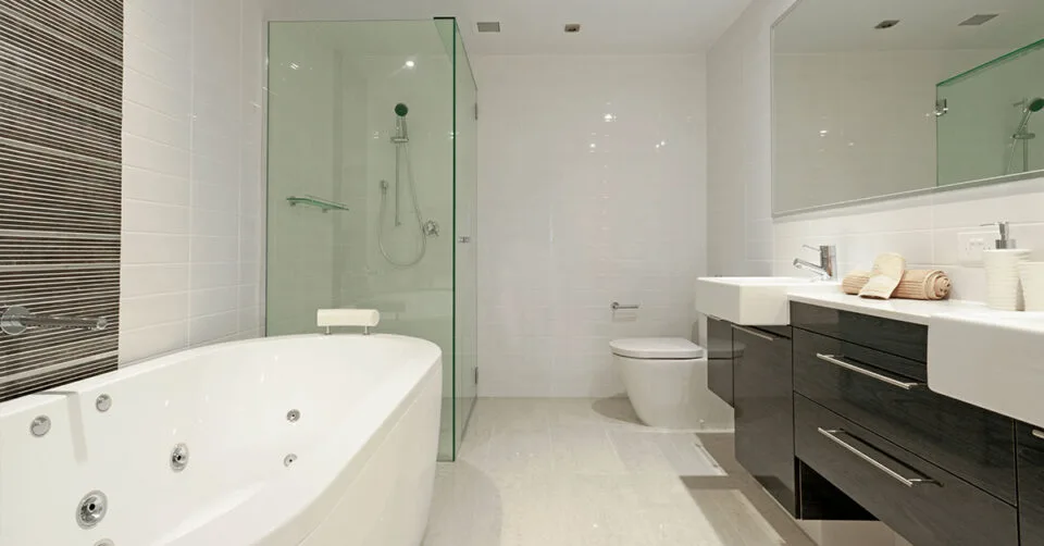 Modern bathroom with a spa tub, glass shower, double sinks, and sleek cabinetry.